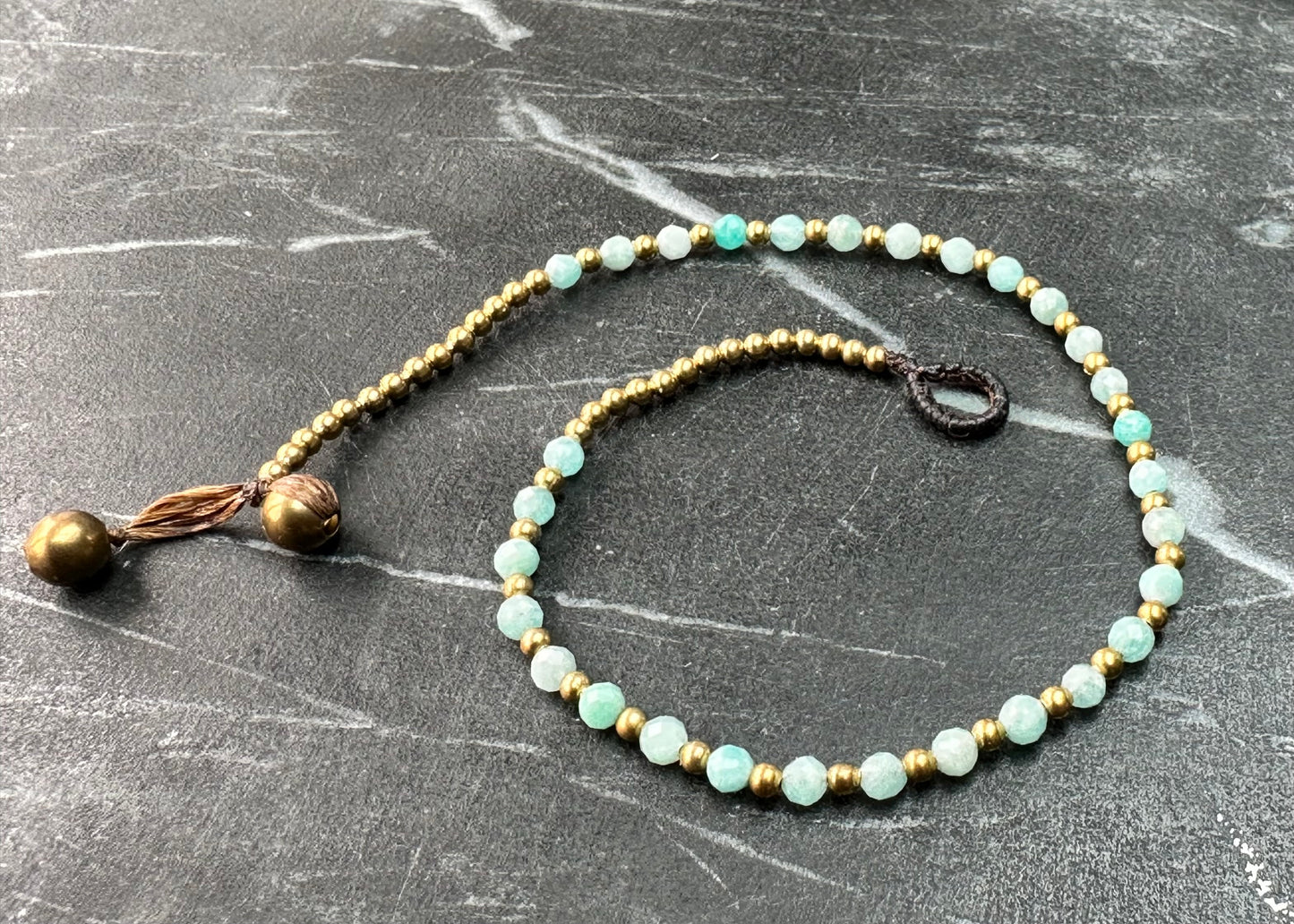 a crystal healing anklet made of faceted Amazonite crystals on a cotton cord with brass beads