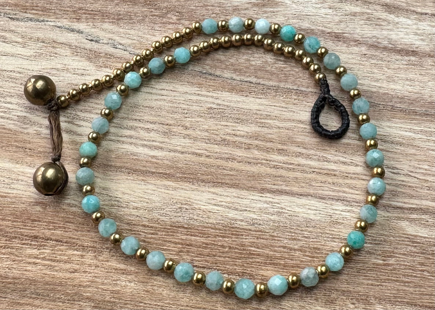 a crystal healing bracelet made of faceted Amazonite crystals on a cotton cord with brass beads